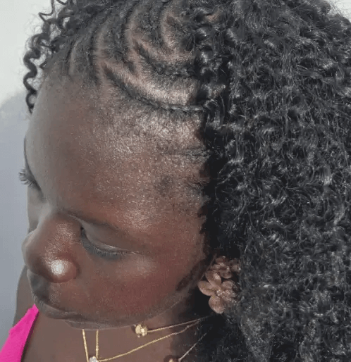 Close-up of a person with styled hair and a pink top.